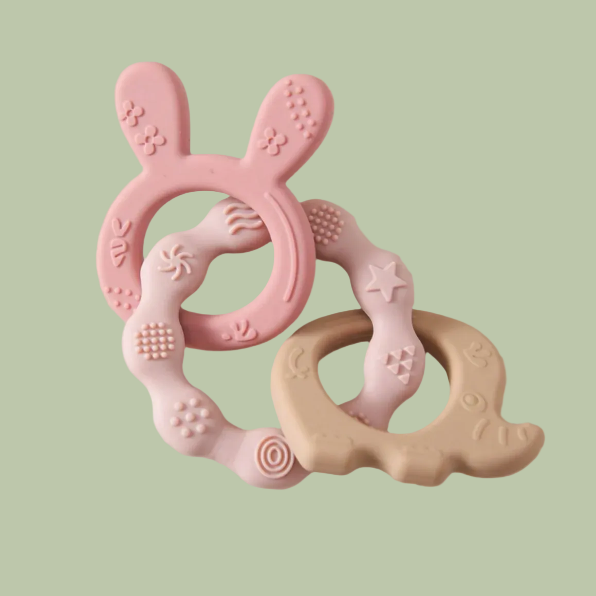 Pink and beige silicone teething ring on a light green background