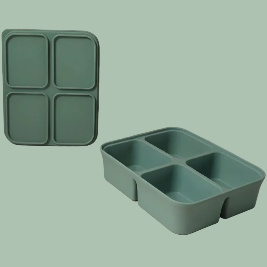 A mint green silicone bento box organizer shown in two views: one standing upright with four square compartments and one lying down in a four-compartment grid, set against a minimalist beige and dusty rose background.