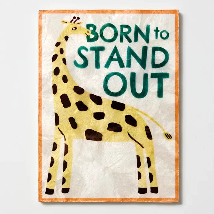 Framed artwork with a giraffe illustration and 'Born to Stand Out' text on a light gray background