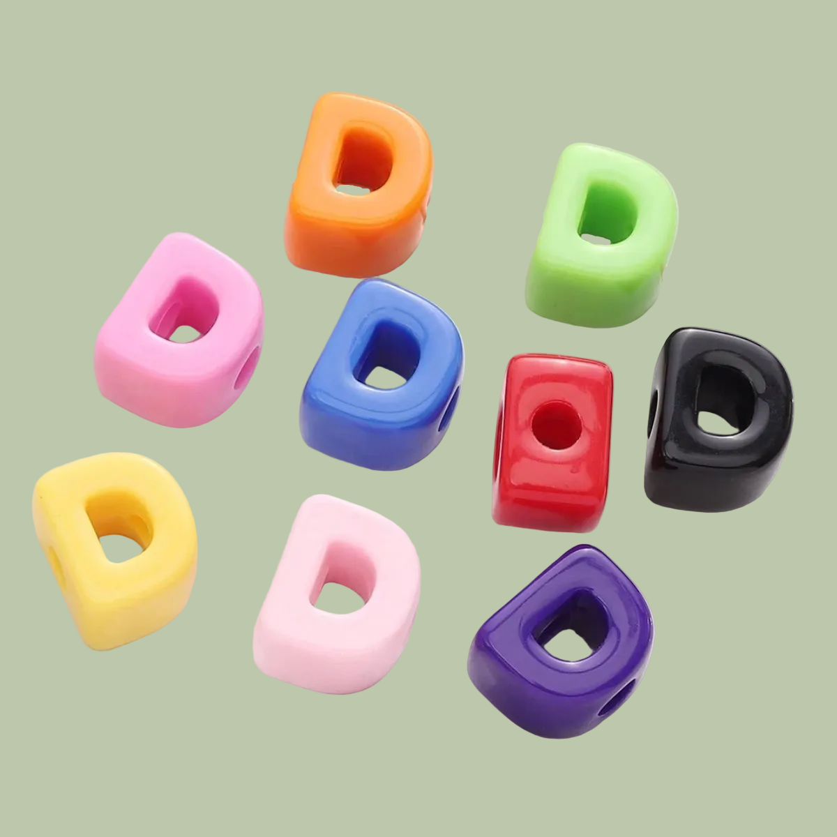 Colorful letter 'D' beads on a white surface
