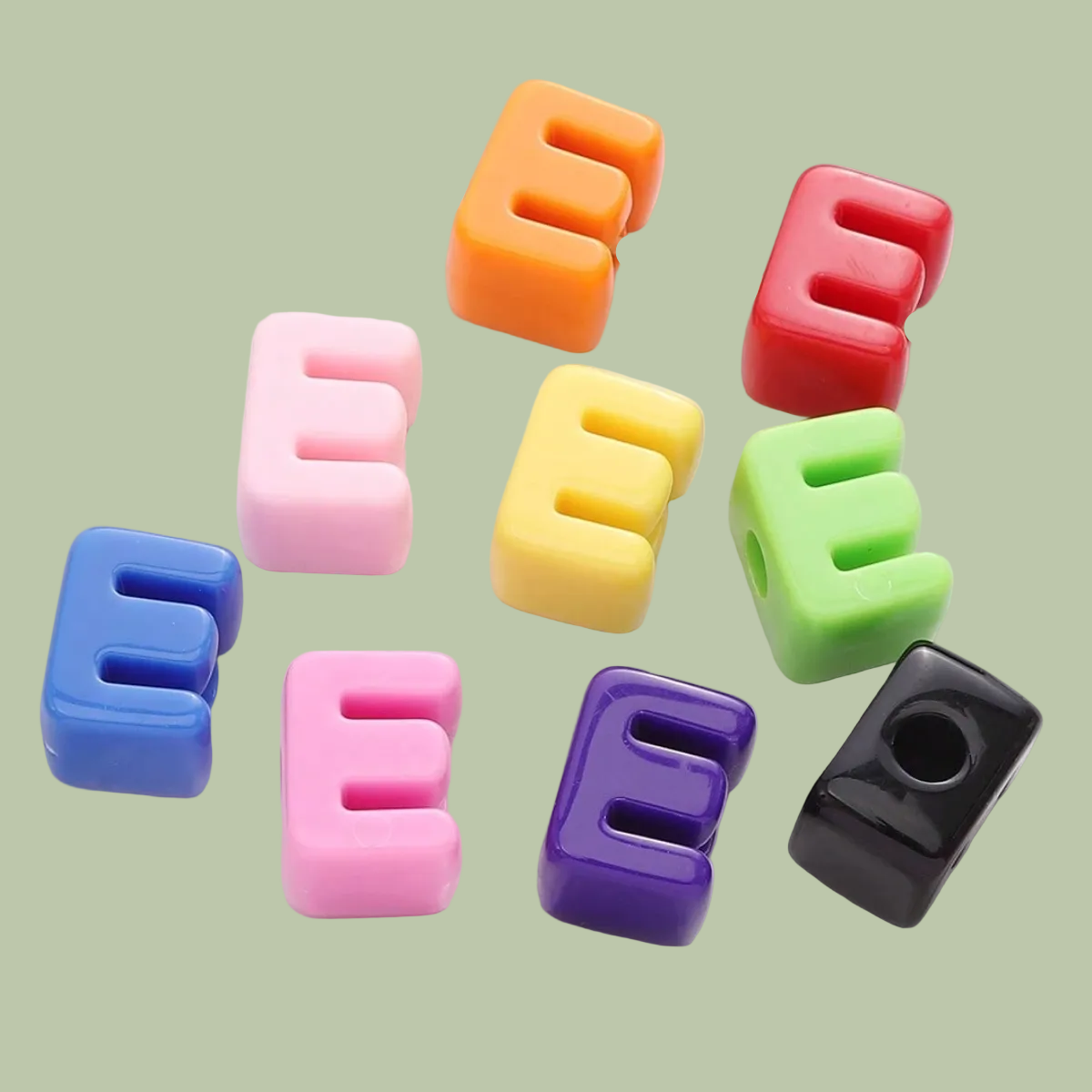 Colorful letter-shaped candies on sticks arranged on a white plate.