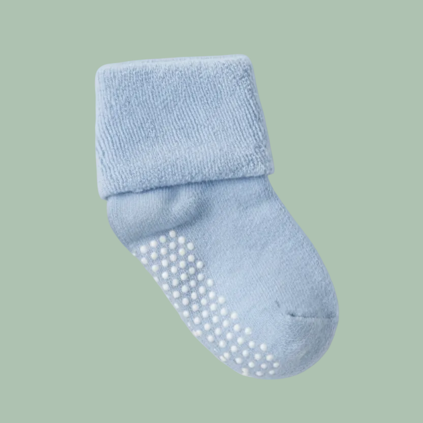 A pair of baby socks with textured grip dots on the soles, displayed on a white surface. 