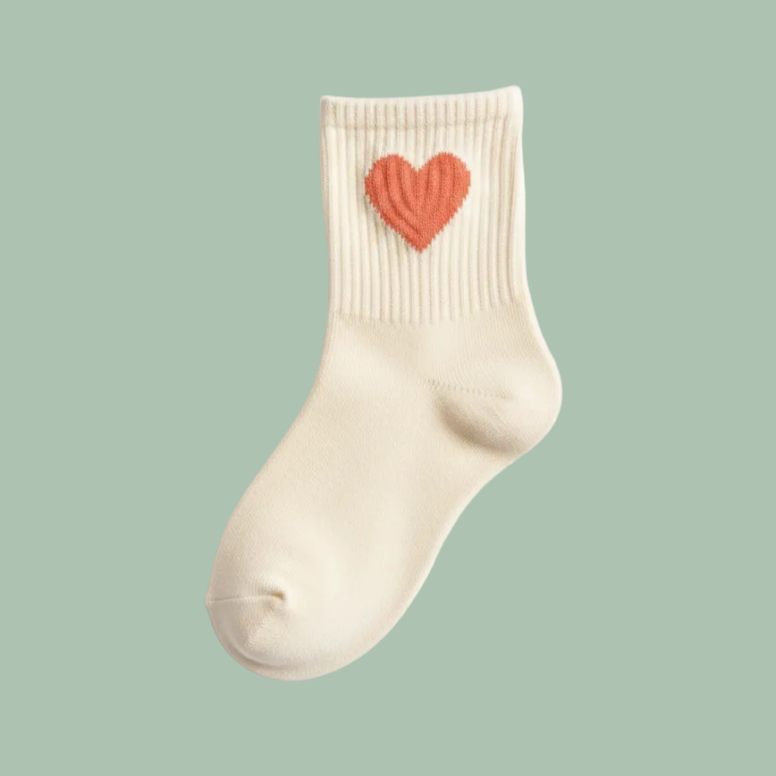 A single cream-colored ribbed ankle sock with a textured coral-pink heart embroidered on the cuff, shown against a plain white background.