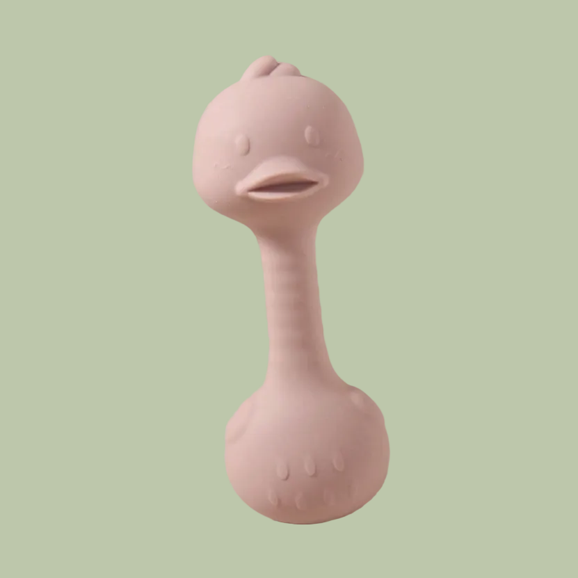 Pink baby rattle on a beige background
