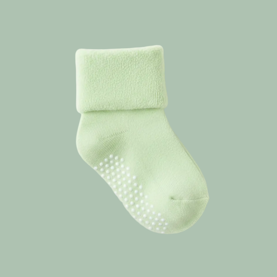 A pair of soft baby socks with textured non-slip grip dots on the sole