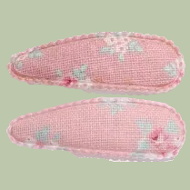 Two pink fabric eye pillows with floral patterns on a white background