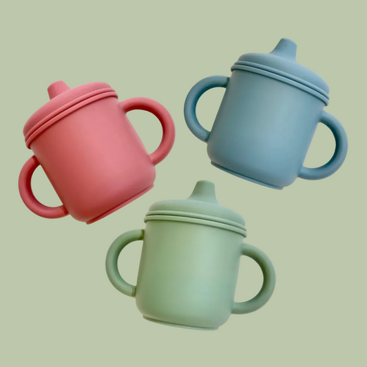 Three colorful sippy cups on a white background