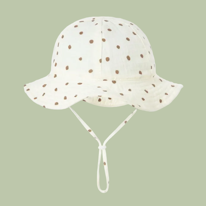 White sun hat with brown polka dots on a white background