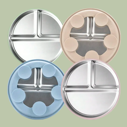 Four round stainless steel divided plates in different colors on a white background
